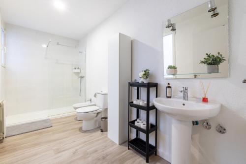 ein Badezimmer mit Waschbecken, Toilette und Spiegel in der Unterkunft Amati Boutique Coliving Madrid in Madrid
