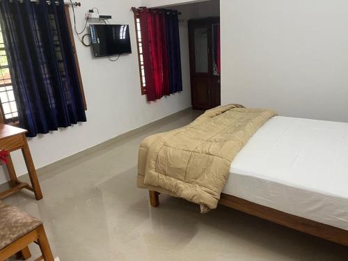 a bedroom with a bed and a tv in it at Mulberry homestay Munnar in Anaviratty