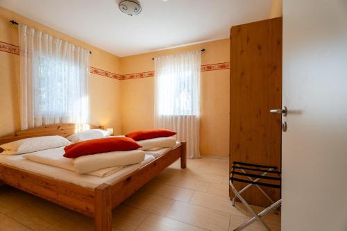 een slaapkamer met twee bedden met rode en witte kussens bij Casa Mia by K A M E L U in Gengenbach