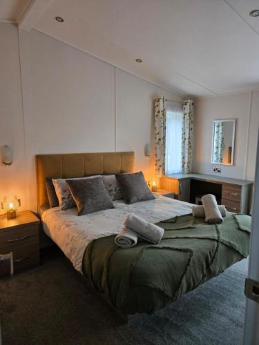 a bedroom with a large bed with two towels on it at JJs Lodge Jorvik in Walkington