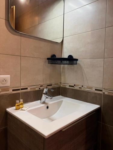 ein Badezimmer mit Waschbecken und Spiegel in der Unterkunft La Ruche, Maison chaleureuse de 5 personnes in Aigueblanche