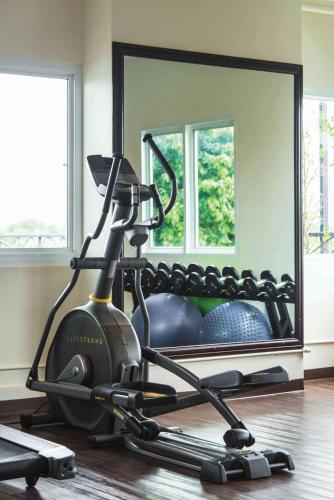 a room with a exercise bike and a mirror at The Bridge Residence Hotel in Kanchanaburi