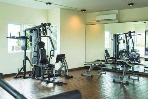 a gym with several tread machines in a room at The Bridge Residence Hotel in Kanchanaburi