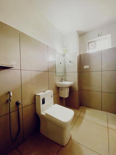 a bathroom with a toilet and a sink at Metro Residency in Perintalmanna
