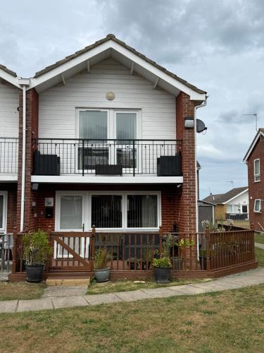 a brick house with a balcony on top of it at 30 Waterside in Corton