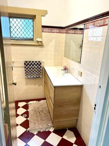 a bathroom with a sink and a mirror at 3BR Guest House near Adelaide CBD Joslin 5070 in Evandale