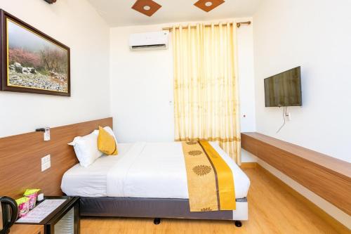 a hotel room with a bed and a tv at Long Anh Hotel in Lao Cai