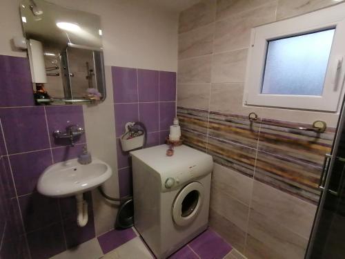 a bathroom with a toilet and a sink at Apartman LAVANDA in Šumarak