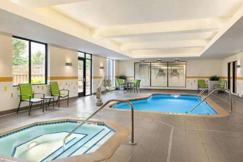 einen Pool in einem Hotelzimmer mit Stühlen und einem Tisch in der Unterkunft Fairfield Inn & Suites by Marriott St. Paul Northeast in Vadnais Heights