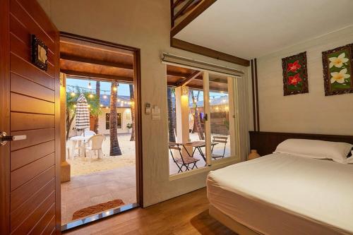 1 dormitorio con 1 cama y puerta que conduce a un patio en 峇里島漫活民宿Bali Slow Homestay, en Dongshan