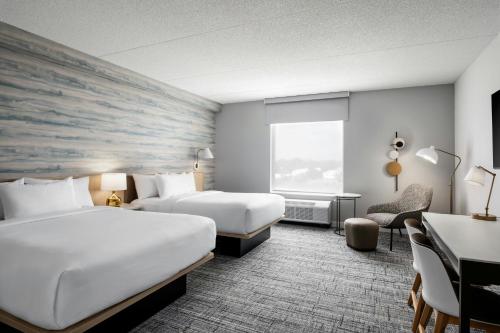 TownePlace Suites by Marriott Tecumseh Windsor في Tecumseh: غرفة فندق بها سريران ومكتب