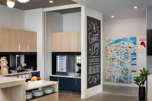 TownePlace Suites by Marriott Tecumseh Windsor في Tecumseh: مطبخ به سبورة كبيرة على الحائط