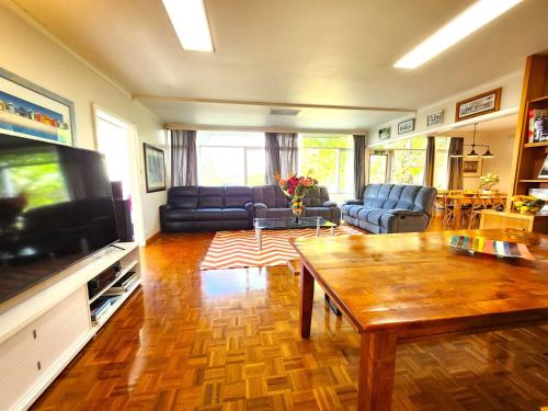 a living room with a couch and a table at Large quad guest room 6 with well-equipped kitchen in Highett