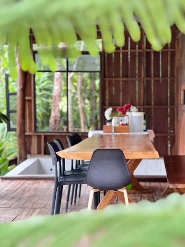 a wooden table and chairs on a patio at Baanraipoonwana Baanboonmak in Ban Don Klang