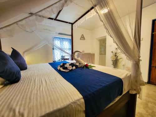 Sky Villa Unawatuna في يوناواتونا: غرفة نوم بها سرير مع لحاف أزرق وأبيض