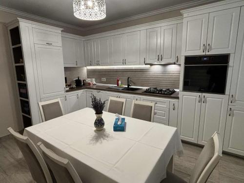 een witte keuken met een witte tafel en stoelen bij Casa Carolina in Alba Iulia