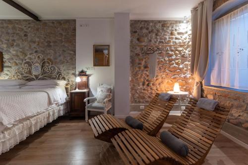 a bedroom with a bed and two chairs and a window at GardaBeds Adults Only in Castelnuovo del Garda