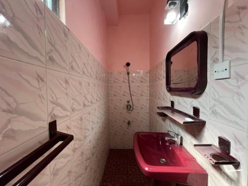 a bathroom with a red sink and a mirror at RIVINSON Negombo in Negombo