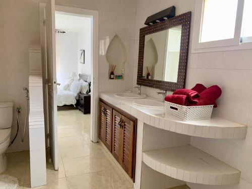 un baño con lavabo y espejo en Amarante, en Saly Portudal