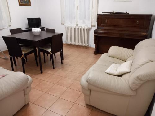a living room with a couch and a table and a piano at Casa Travaglini in Fano