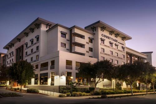 a large white building with trees in front of it at Courtyard by Marriott Redwood City in Redwood City