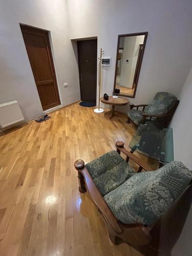 un soggiorno con due sedie e un pavimento in legno di Apartment Central a Baku