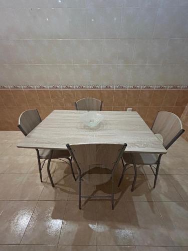 une table avec quatre chaises et une table blanche avec des chaises dans l'établissement Apartment Central, à Baku