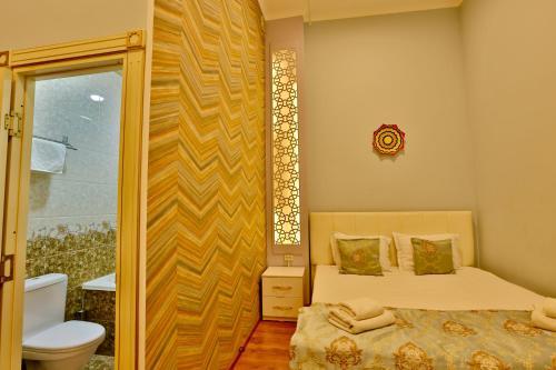 una piccola camera con letto e servizi igienici di AaSia a Bukhara