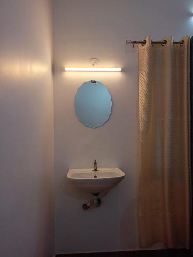 a bathroom with a sink and a shower curtain at Phoenix Villa in Kappil