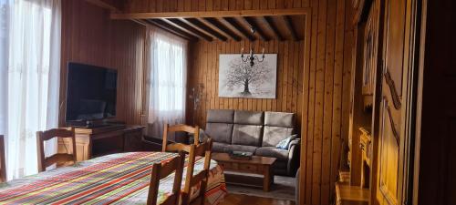a living room with a couch and a television at Maison au coeur du Jura - 4 chambres - 9 couchages in Champagnole