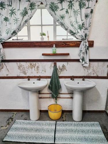 a bathroom with two sinks and a window at 2K City Studios Not Self catering in Graskop
