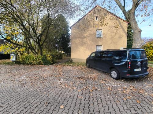 een zwart busje geparkeerd voor een gebouw bij Mego Unterkünfte 3 in Bönen