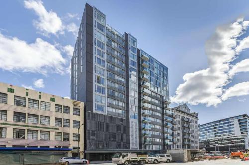 a tall building with cars parked in front of it at 3-Bedroom CBD Elevate Apartment in Wellington