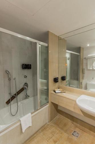 a bathroom with a tub and a sink and a shower at Capsis Bristol Boutique Hotel in Thessaloniki
