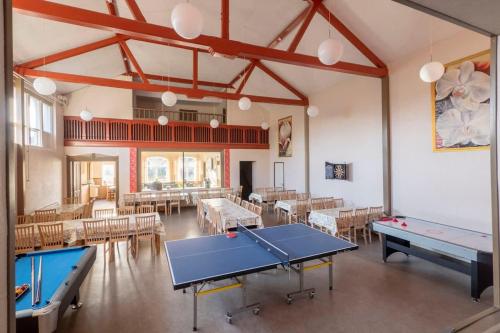 an empty room with tables and ping pong tables at Big Family Home Near Romo Spacious for 30 Guests in Skærbæk