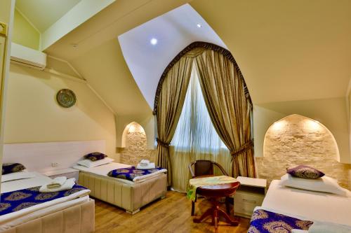 una camera d'albergo con tre letti e una finestra di AaSia a Bukhara