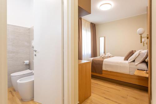 a bedroom with a bed and a bathroom with a tub at Guest House Aura - Lumys Fiumicino in Fiumicino