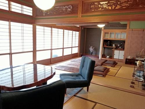 una sala de estar con una mesa y sillas de cristal en しまなみ海道お宿ぽんぽこ, en Imabari