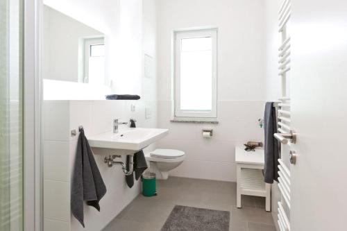 a white bathroom with a sink and a toilet at Am Hafen 8 in Röbel
