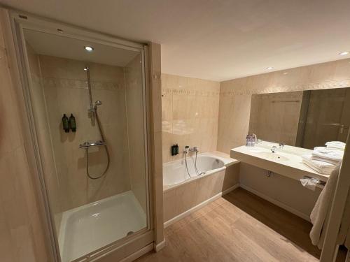 a bathroom with a shower and a tub and a sink at Hôtel Panorama - Vue exceptionnelle sur la Semois in Bouillon