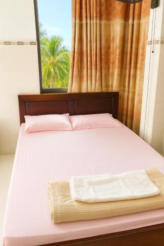 a bedroom with a bed with a window at Bảo Ngọc Hotel Đông Hà in Quang Tri