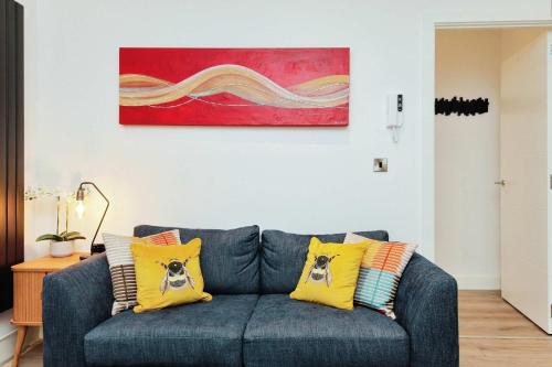 a living room with a blue couch with yellow pillows at Solihull Modern Living - 1 Bed Apartment in Solihull