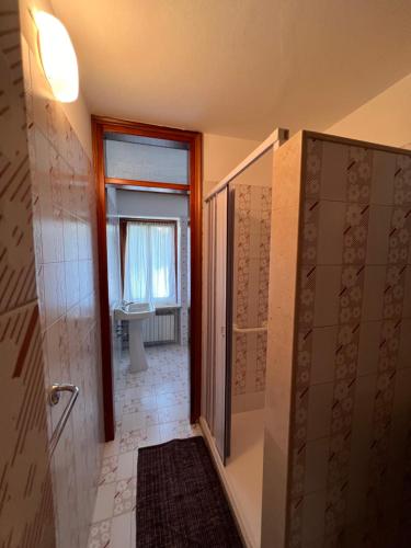 Conveniente, tranquilla con parcheggio في بيلونو: حمام مع دش ومرحاض ونافذة