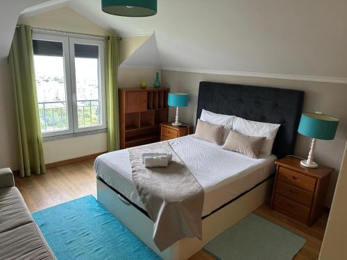una camera da letto con un letto, due lampade e una finestra di Moniz Apartment a Caniço