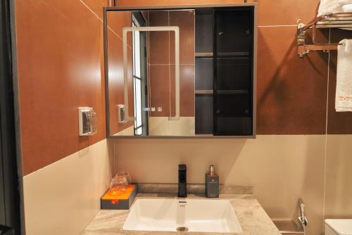 a bathroom with a sink and a mirror at H- Dragon Hotel in Ðông Thôn