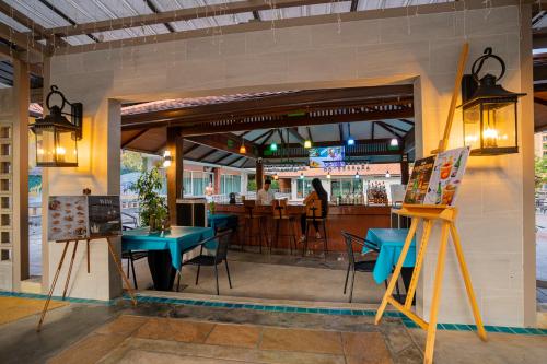 a restaurant with tables and chairs and a bar at Khum Phucome Hotel -SHA Extra Plus in Chiang Mai