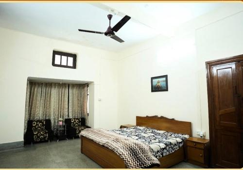a bedroom with a bed and a ceiling fan at Prayag Homestay in Prayagraj