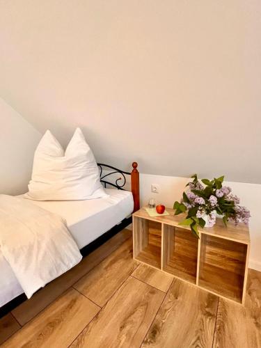 ein Schlafzimmer mit einem Bett und einem Tisch mit Blumen in der Unterkunft Pamela in Eußenheim