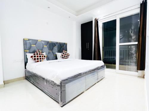 Un dormitorio con una cama grande y una ventana grande. en Hotel 24 Stay - Near Max Hospital, en Nueva Delhi