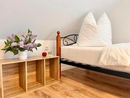 ein Schlafzimmer mit einem Bett und zwei Tischen mit Blumen in der Unterkunft Pamela in Eußenheim